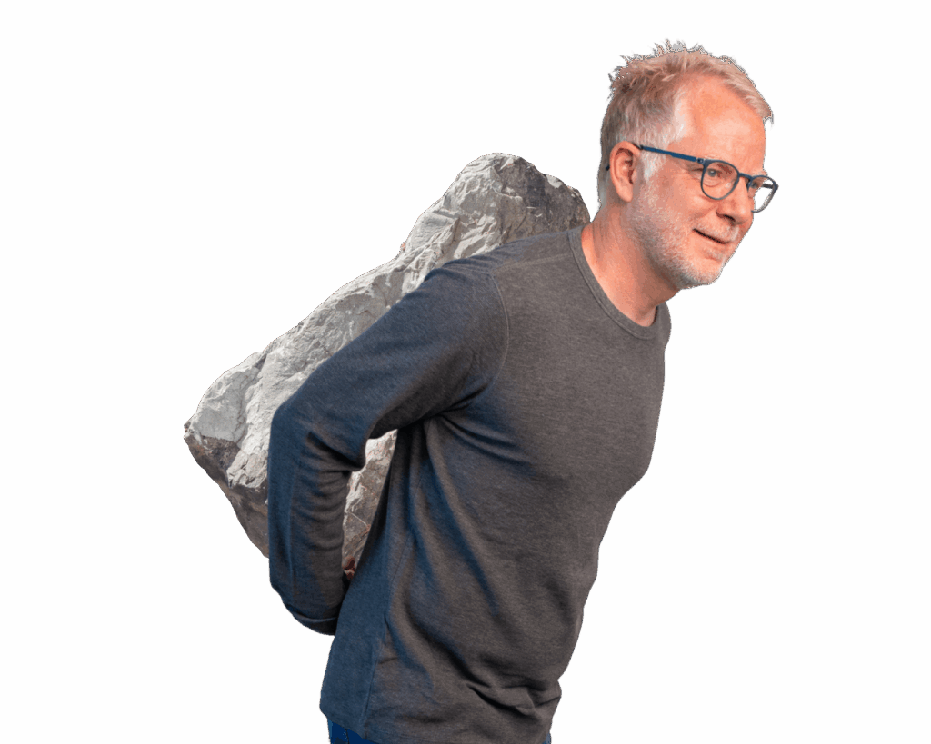 Johannes lächelt mit einem Felsen über der Schulter